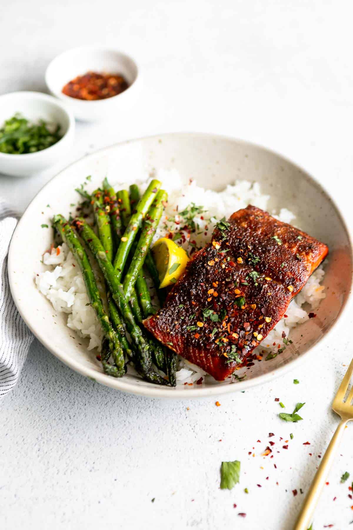salmon in air fryer in a bowl with rice and asparagus