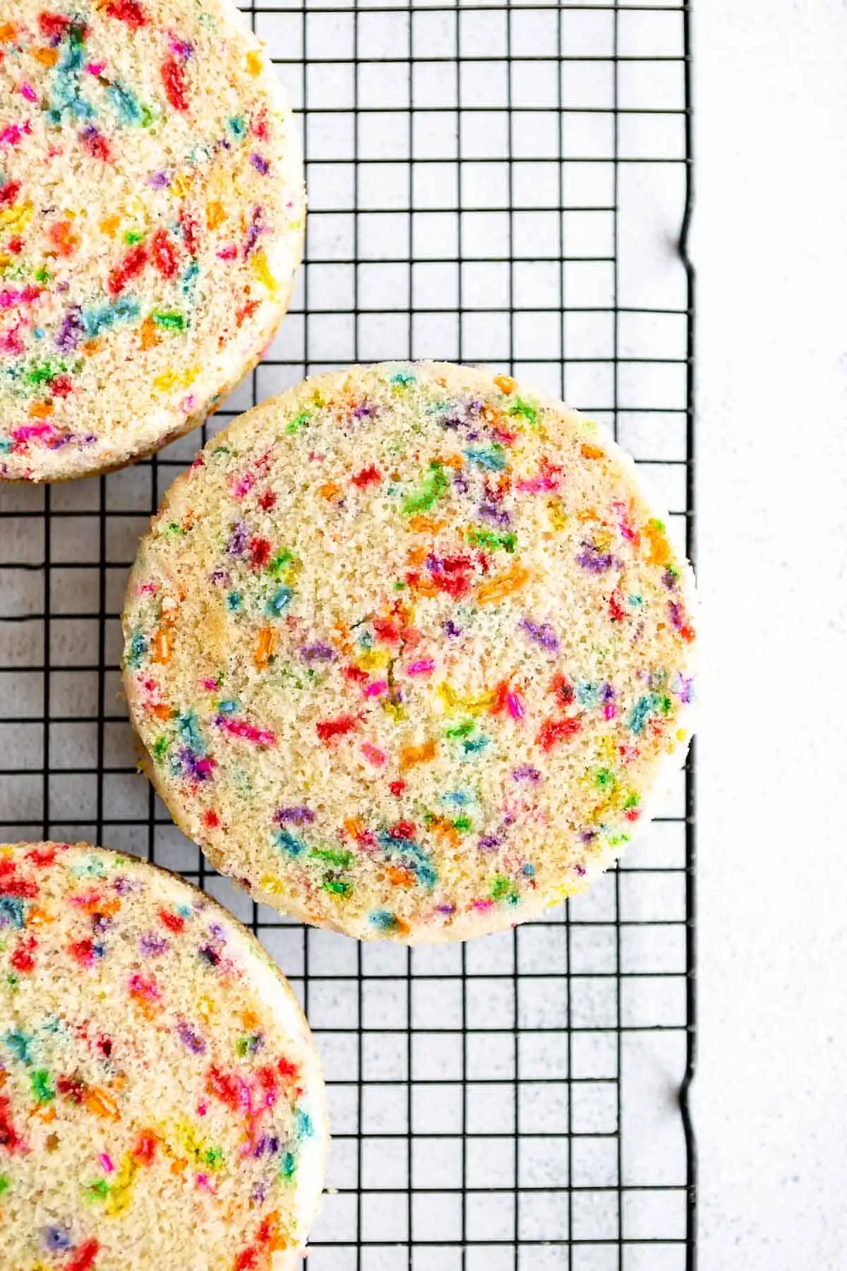 funfetti cake on a cooling rack after baking